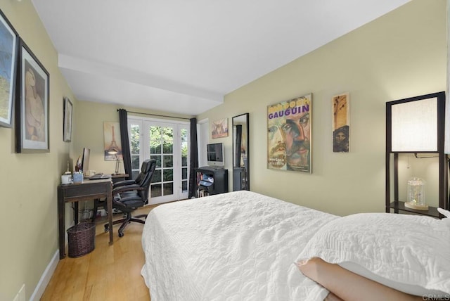 bedroom with baseboards, french doors, light wood-type flooring, and access to exterior