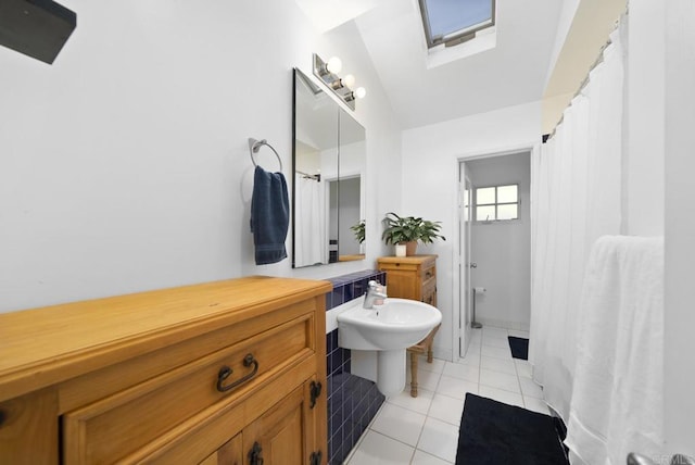 bathroom featuring lofted ceiling and tile patterned flooring