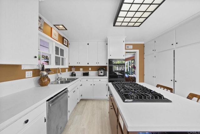 kitchen with stainless steel appliances, light countertops, white cabinetry, and a center island