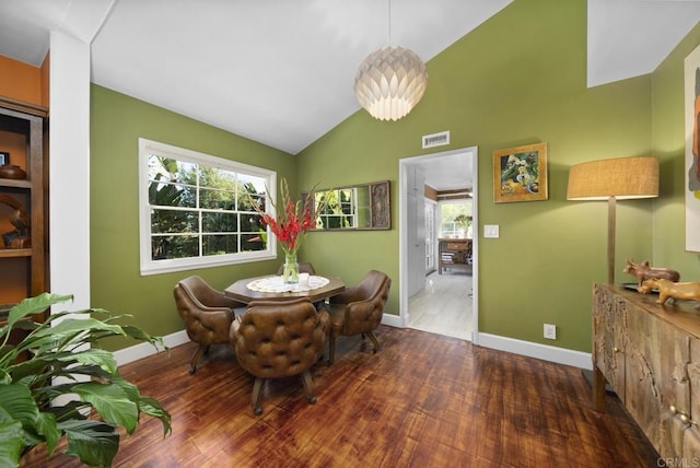 dining area with baseboards, visible vents, vaulted ceiling, and dark wood-type flooring