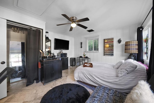 bedroom with ceiling fan, multiple windows, and attic access