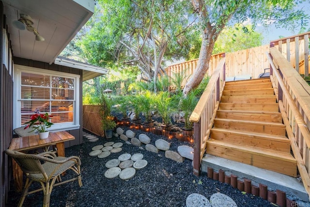 view of yard with fence and stairway