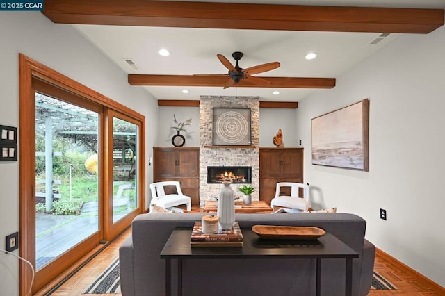 living room featuring beamed ceiling, ceiling fan, light parquet flooring, and a fireplace