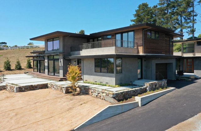 back of house featuring a garage and a balcony