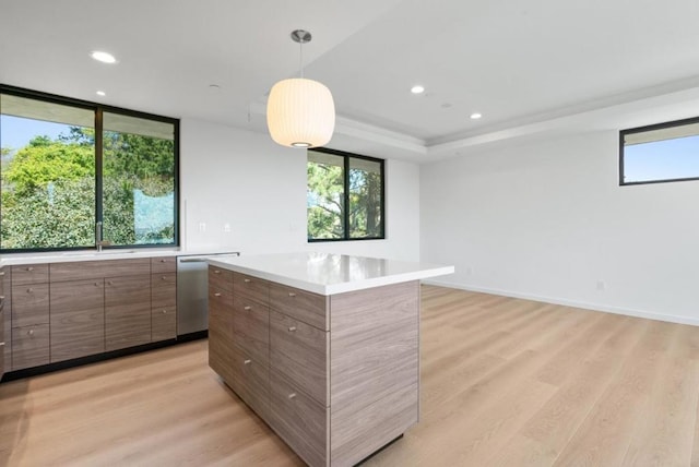 kitchen with pendant lighting, stainless steel dishwasher, light hardwood / wood-style floors, and a kitchen island