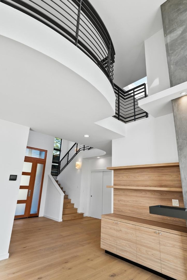 stairs with a towering ceiling and wood-type flooring