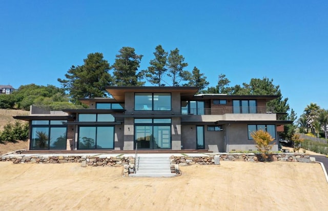 rear view of property featuring a patio and a balcony