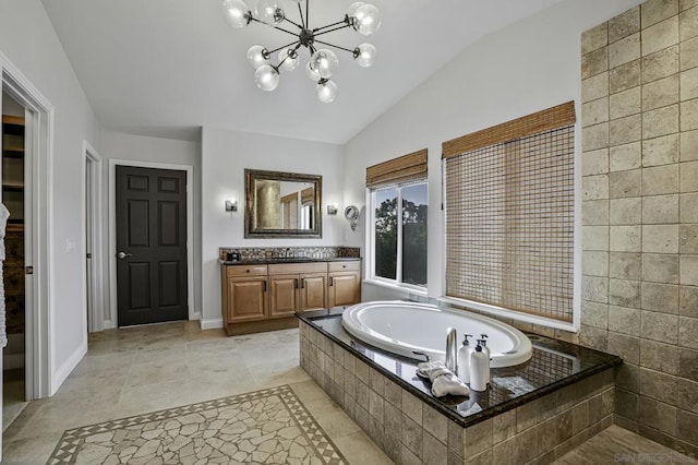 bathroom featuring vaulted ceiling, a relaxing tiled tub, vanity, and a chandelier