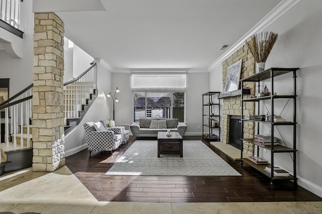 living room featuring crown molding, a stone fireplace, and dark hardwood / wood-style floors