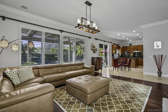 living room featuring an inviting chandelier, ornamental molding, and dark hardwood / wood-style floors