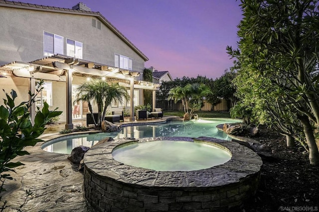 pool at dusk with an in ground hot tub, a patio, and a pergola