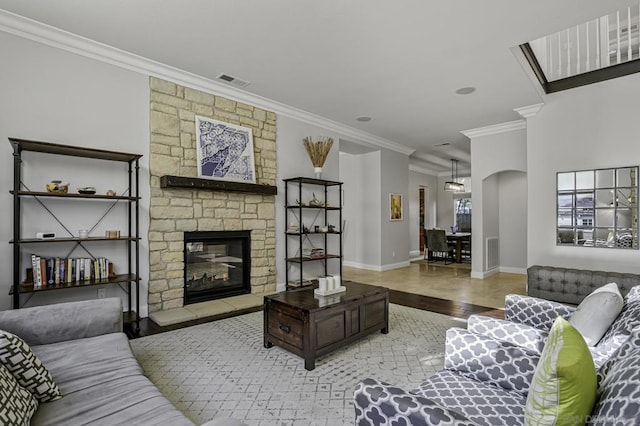 living room featuring crown molding, a fireplace, and light hardwood / wood-style flooring