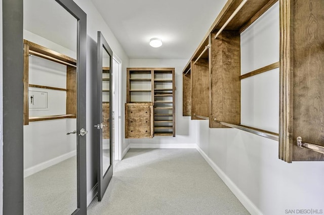 walk in closet featuring light colored carpet