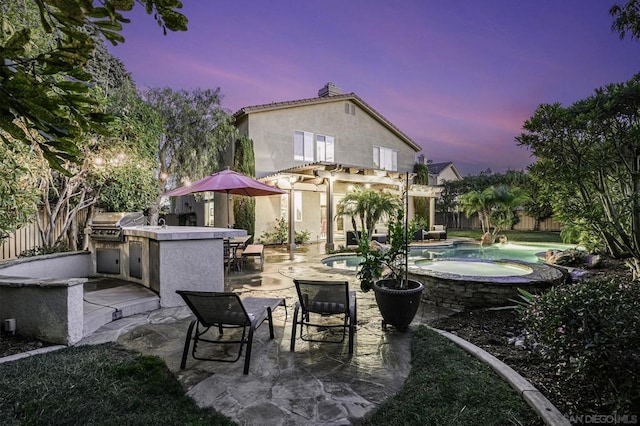 patio terrace at dusk with area for grilling, a swimming pool with hot tub, a pergola, a bar, and an outdoor kitchen