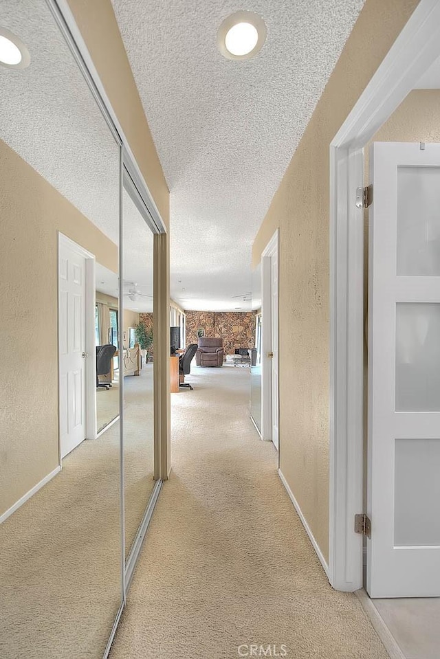 hallway featuring carpet floors and a textured ceiling