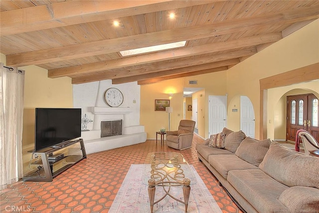 living room with wood ceiling, a fireplace, a skylight, and beamed ceiling