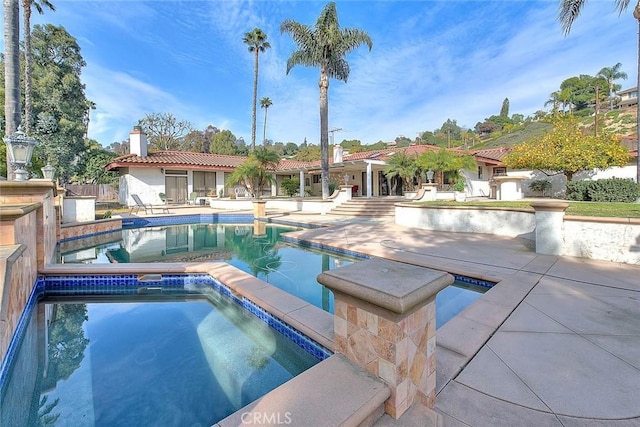 view of pool with an in ground hot tub and a patio area