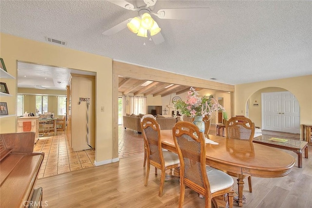 dining room with ceiling fan, a textured ceiling, and light hardwood / wood-style flooring