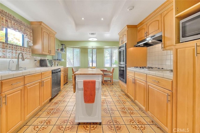 kitchen featuring stainless steel appliances, tile counters, and light tile patterned floors