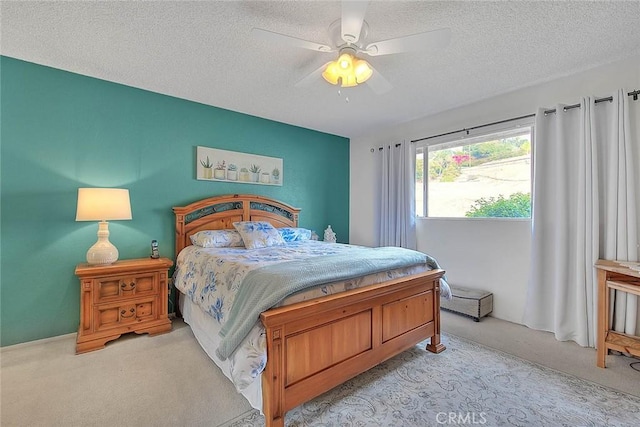 carpeted bedroom with ceiling fan and a textured ceiling