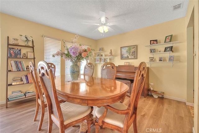 dining area featuring ceiling fan, a textured ceiling, and light hardwood / wood-style floors