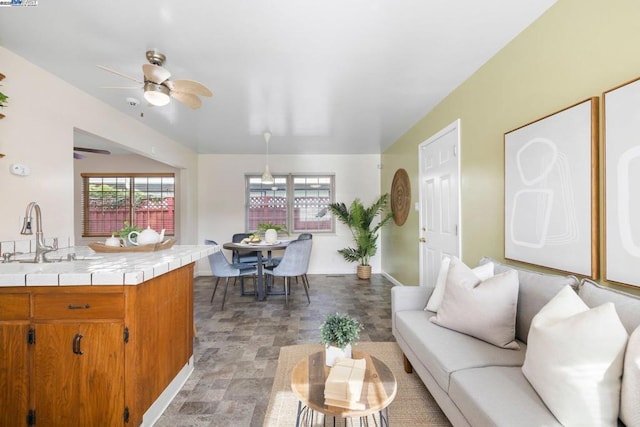 living room featuring ceiling fan and sink