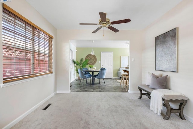 living area with carpet flooring and ceiling fan