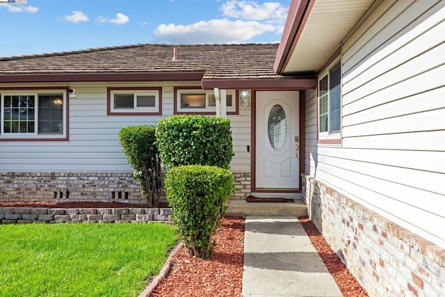 doorway to property with a lawn