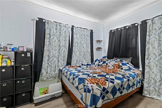 bedroom with hardwood / wood-style flooring and ornamental molding