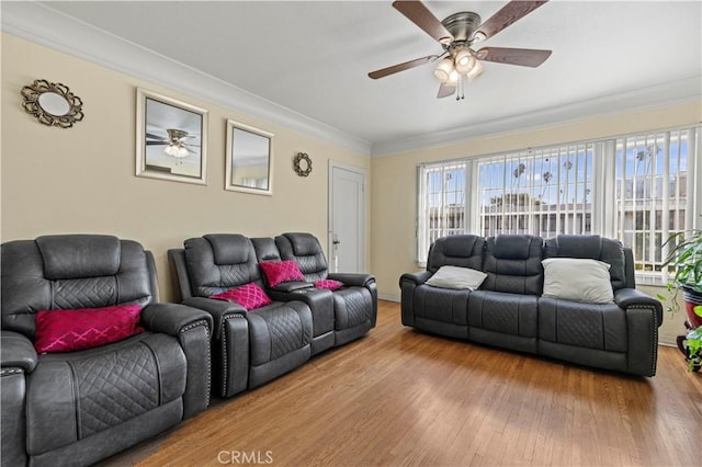 living room with ornamental molding, wood-type flooring, and ceiling fan