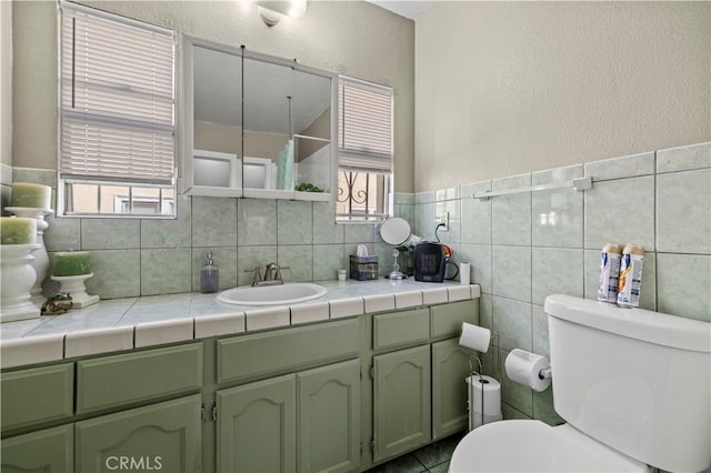 bathroom featuring tile walls, vanity, and toilet