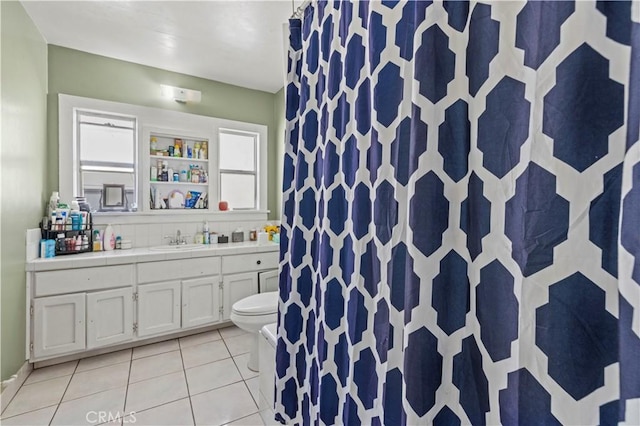 bathroom featuring toilet, vanity, tile patterned floors, and decorative backsplash