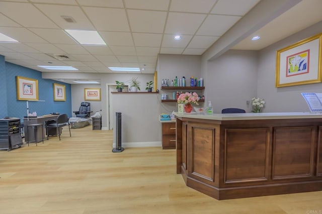 interior space featuring visible vents, baseboards, a drop ceiling, light wood-style floors, and recessed lighting