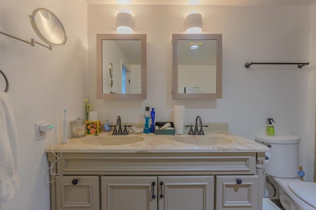 full bathroom featuring a sink, toilet, and double vanity