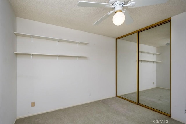 unfurnished bedroom featuring light colored carpet, a closet, and a textured ceiling