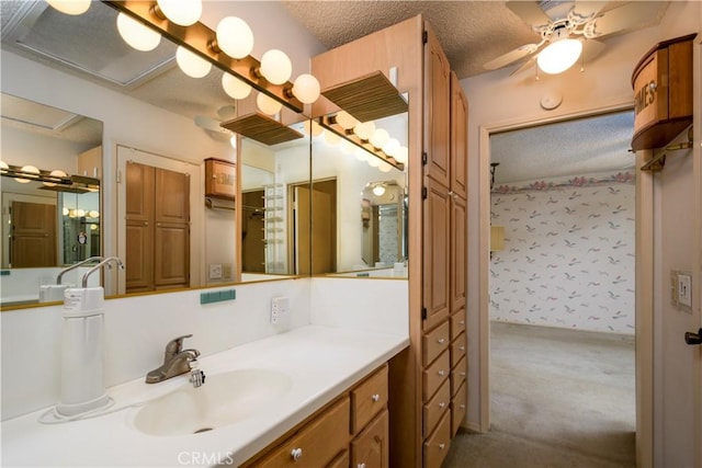 bathroom with vanity, ceiling fan, and a textured ceiling