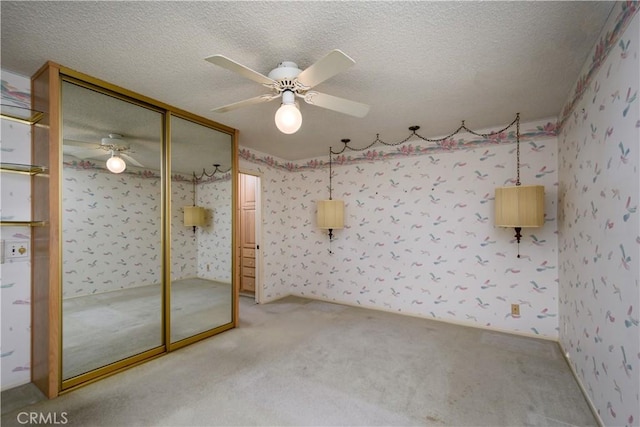 interior space with ceiling fan, carpet, a textured ceiling, and a closet