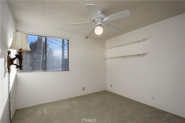 carpeted spare room with ceiling fan and a textured ceiling