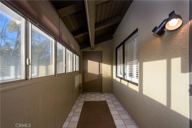 unfurnished sunroom featuring plenty of natural light, vaulted ceiling with beams, and wooden ceiling