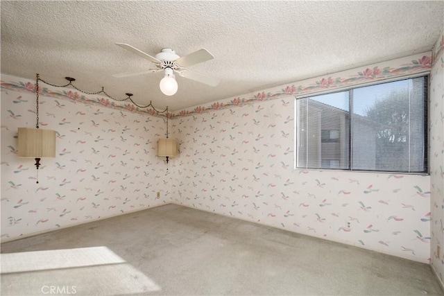 carpeted spare room featuring ceiling fan and a textured ceiling