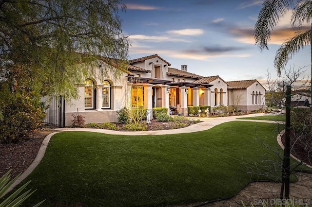 mediterranean / spanish home featuring a lawn