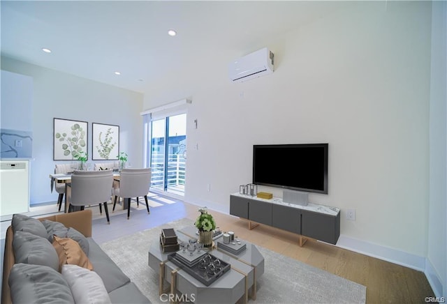 living room featuring a wall mounted air conditioner and light hardwood / wood-style flooring