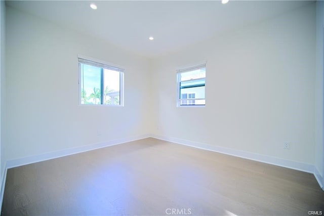 empty room with plenty of natural light and wood-type flooring