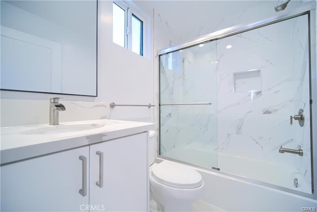 full bathroom featuring toilet, vanity, and shower / bath combination with glass door