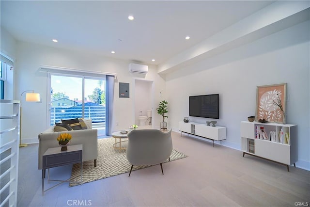 living room featuring a wall mounted AC and light hardwood / wood-style floors