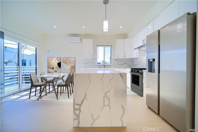 kitchen featuring white cabinetry, hanging light fixtures, backsplash, stainless steel appliances, and a wall mounted AC