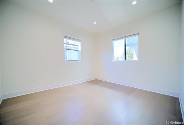 unfurnished room with hardwood / wood-style flooring and a healthy amount of sunlight