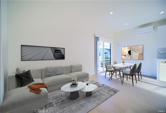 living room featuring light hardwood / wood-style floors and an AC wall unit