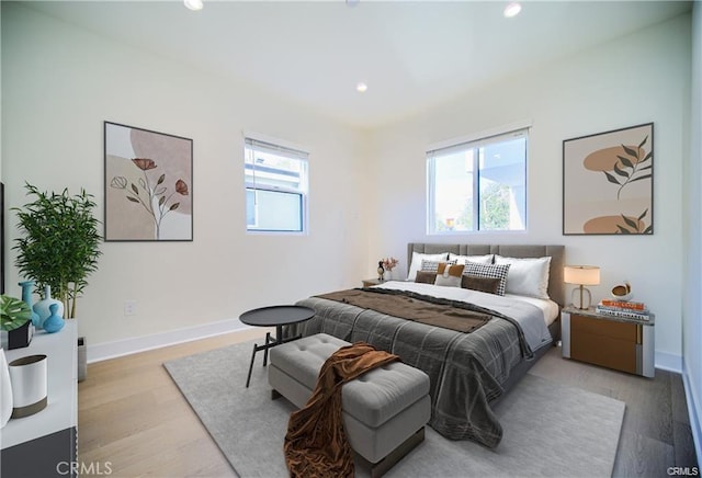 bedroom featuring multiple windows and light wood-type flooring