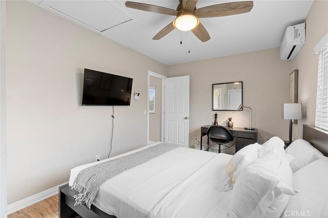 bedroom with ceiling fan, an AC wall unit, light wood-type flooring, and baseboards